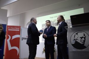 dyrektor szkoły wraz z wicekuratorem wręczają statuetkę przedstawicielowi rady rodziców