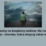 Tło grafiki: Tło jest w jednolitym, stonowanym kolorze – jasnoszarym o chłodnym odcieniu, który nie rozprasza uwagi i buduje spokojny nastrój. Centralna część grafiki – zdjęcie: W górnej części grafiki znajduje się zdjęcie zajmujące około 1/3 wysokości obrazu. Przedstawia samotną postać siedzącą na drewnianym pomoście nad spokojnym jeziorem. Kompozycja zdjęcia przekazuje uczucie smutku, izolacji i zamyślenia. Postać: Na środku kadru siedzi młoda osoba (prawdopodobnie dziewczynka lub nastolatka) tyłem do widza. Ma długie, jasnobrązowe lub ciemny blond włosy. Ubrana jest w luźną, jasnozieloną bluzę z kapturem i niebieskie spodnie. Siedzi ze zgiętymi kolanami, przyciągniętymi do klatki piersiowej, z głową pochyloną lekko w dół, co wyraża introspekcję lub smutek. Otoczenie: Dziewczyna siedzi na drewnianym pomoście w ciemnym, ciepłym brązie, który wystaje nad wodę. Woda jest spokojna, lustrzana – odbija niebo pokryte chmurami w odcieniach niebiesko-szarych. Nie widać innych ludzi ani elementów przyrody – krajobraz jest pusty i cichy, co potęguje nastrój samotności. Dolna część grafiki – tekst: Pod zdjęciem, na tle tego samego jasnoszarego tła, znajduje się czytelny czarny tekst w dużym, pogrubionym kroju bezszeryfowym: "Zapraszamy na bezpłatny webinar dla rodziców. 'Depresja – choroba, która dotyczy także młodych'" Tekst jest wyśrodkowany i zapisany prostym, nowoczesnym fontem bez dodatkowych ozdobników, co ułatwia czytanie osobom z trudnościami wzrokowymi lub poznawczymi. Cudzysłów otwierający i zamykający polski („”) nie został użyty – wykorzystano angielski ("). Wrażenie ogólne i przekaz: Grafika emanuje spokojem, ale też smutkiem i zadumą. W połączeniu z treścią tekstu jednoznacznie wskazuje na temat depresji u młodzieży oraz potrzebę wsparcia ze strony dorosłych. Przeznaczona jest dla rodziców i opiekunów, których celem jest zrozumienie problemu oraz udział w darmowym webinarze edukacyjnym.