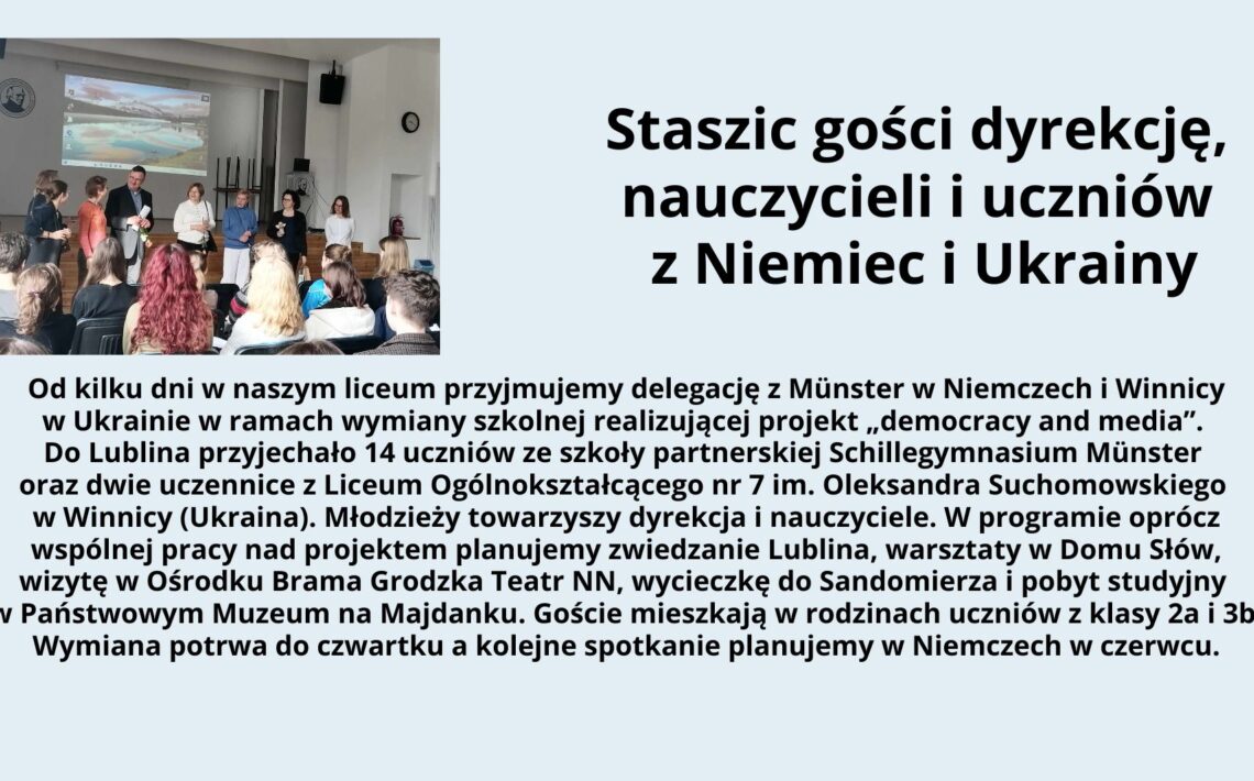 Grafika składa się z dwóch części: zdjęcia po lewej stronie oraz tekstu po prawej stronie na jasnoniebieskim tle. Zdjęcie: Przedstawia scenę w sali szkolnej z drewnianą podłogą i białymi ścianami. Na ścianie w tle widoczny jest ekran z projektorem, na którym wyświetlono obraz przedstawiający krajobraz z wodą i górami. Na scenie stoi siedem osób – pięć dorosłych i dwie młodsze osoby, prawdopodobnie uczniowie. Dorośli są elegancko ubrani – mężczyzna w garniturze, kobiety w swetrach lub marynarkach. Wśród nich jedna osoba trzyma mikrofon, a reszta uśmiecha się i patrzy na publiczność. Publiczność składa się z uczniów siedzących na krzesłach; niektórzy mają widoczne kolorowe ubrania, w tym dziewczyna z długimi rudymi włosami w czerwonej bluzie. Tekst: Po prawej stronie znajduje się blok tekstu w języku polskim. Nagłówek w dużej czarnej czcionce głosi: „Staszic gości dyrekcję, nauczycieli i uczniów z Niemiec i Ukrainy” Poniżej znajduje się akapit tekstu w mniejszej czcionce: Od kilku dni w naszym liceum przyjmujemy delegację z Münster w Niemczech i Winnicy w Ukrainie w ramach wymiany szkolnej realizującej projekt „democracy and media”. Do Lublina przyjechało 14 uczniów ze szkoły partnerskiej Schillegymnasium Münster oraz dwie uczennice z Liceum Ogólnokształcącego nr 7 im. Oleksandra Suchomowskiego w Winnicy (Ukraina). Młodzieży towarzyszy dyrekcja i nauczyciele. W programie oprócz wspólnej pracy nad projektem planujemy zwiedzanie Lublina, warsztaty w Domu Słów, wizytę w Ośrodku Brama Grodzka Teatr NN, wycieczkę do Sandomierza i pobyt studyjny w Państwowym Muzeum na Majdanku. Goście mieszkają w rodzinach uczniów z klasy 2a i 3b. Wymiana potrwa do czwartku a kolejne spotkanie planujemy w Niemczech w czerwcu. Cała grafika jest estetycznie uporządkowana, z dobrze widocznym tekstem na kontrastowym tle, co poprawia czytelność.