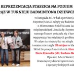 Nagłówek główny – wyśrodkowany, duży, czarny: „REPREZENTACJA STASZICA NA PODIUM – BRĄZ W TURNIEJU BADMINTONA DZIEWCZĄT!” Tekst właściwy – po prawej stronie plakatu: Tekst jest w klasycznej czcionce szeryfowej. Zawiera informację o wydarzeniu sportowym. Fragmenty „III miejsce” oraz nazwiska medalistek zapisane są w czerwonym kolorze dla podkreślenia. Treść: „13 listopada br., w hali sportowej Centrum Kultury Fizycznej UMCS odbyły się badmintonowe rozgrywki o Mistrzostwo Szkół Miasta Lublin w ramach międzyszkolnej Licealiady. Reprezentacja dziewcząt naszego liceum pokazała się z bardzo dobrej strony wygrywając bez większych problemów swoje mecze. W całym turnieju tylko raz uległa przeciwniczkom i ostatecznie zajęła III miejsce w klasyfikacji końcowej. Skład brązowych medalistek: Hanna Zarębska (2D), Daria Krasucka (3B), Barbara Modrzewska (2C). Opiekun Adam Wawrzyniak. Gratulujemy dziewczynom świetnego wyniku i życzymy kolejnych sukcesów!” 📸 Opis zdjęcia – lewa połowa plakatu Zdjęcie przedstawia trzy nastoletnie dziewczyny, stojące obok siebie, uśmiechnięte, pozujące po zakończonych zawodach badmintonowych. Każda z nich ma na szyi medal, a w dłoniach trzyma sprzęt sportowy lub dyplom. Tło zdjęcia Za dziewczętami widać czarny baner z białymi napisami wielkimi literami: „WSPÓŁZAWODNICTWO SPORTOWE MIASTA LUBLIN”. W dolnej części banera znajdują się białe piktogramy przedstawiające różne dyscypliny sportowe. Pod banerem widoczna jest drewniana ściana sali gimnastycznej – prawdopodobnie drabinki. Fotografia wykonana jest w hali sportowej, podłoga jasna, drewniana. 👧 Opis postaci od lewej do prawej 1. Dziewczyna po lewej Wzrost średni, postura szczupła. Włosy ciemne, związane z tyłu w niski kucyk. Ubrana w granatową, luźną bluzę z białym napisem, jasnoszare, szerokie spodnie dresowe i białe sportowe buty. Na szyi ma medal brązowy. W prawej ręce trzyma rakietę do badmintona, w lewej prawdopodobnie końcówkę zawieszki medalu. Uśmiecha się lekko. 2. Dziewczyna w środku Szczupła, włosy ciemne, związane w kucyk. Ubrana w białą bluzę z długim rękawem, ciemne dżinsy i czarne buty. Na szyi również ma medal. W lewej ręce trzyma złoty puchar sportowy z szeroką podstawą. W prawej – biały dyplom. Stoi z szerokim, radosnym uśmiechem. 3. Dziewczyna po prawej Wzrost średni, figura szczupła. Włosy jasne, proste, rozpuszczone do ramion. Ubrana w jasnoszarą bluzę z kieszenią z przodu, czarne dresowe spodnie oraz sportowe buty. Na szyi zawieszony brązowy medal. W prawej ręce trzyma rakietę do badmintona, w lewej – drugi medal lub element zestawu (nie w pełni widoczny). Uśmiecha się delikatnie.