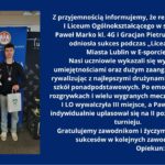 Na grafice po lewej stronie stoją dwaj młodzi mężczyźni w ciemnych ubraniach na tle niebieskiej ścianki z logo „SZS – Szkolny Związek Sportowy”. Jeden trzyma dyplom, drugi puchar i torbę; obaj mają medale na szyi. Po prawej stronie, na granatowym tle, znajduje się biały tekst informujący o sukcesie uczniów I Liceum Ogólnokształcącego w Lublinie – Pawła Marko i Gracjana Pietruszki – w zawodach e-sportowych „Licealiada”. Drużyna zdobyła III miejsce, a Paweł Marko indywidualnie II miejsce. Na końcu widnieją gratulacje oraz podpis: opiekun Paweł Zdeb.