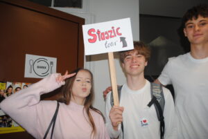 Grupa uczniów pozuje przy drzwiach; jedna osoba trzyma tabliczkę „Staszic tour”.