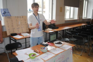 Uczeń przy stanowisku prezentuje zadania matematyczne („taniec funkcji”) przy użyciu planszy i materiałów na stole.