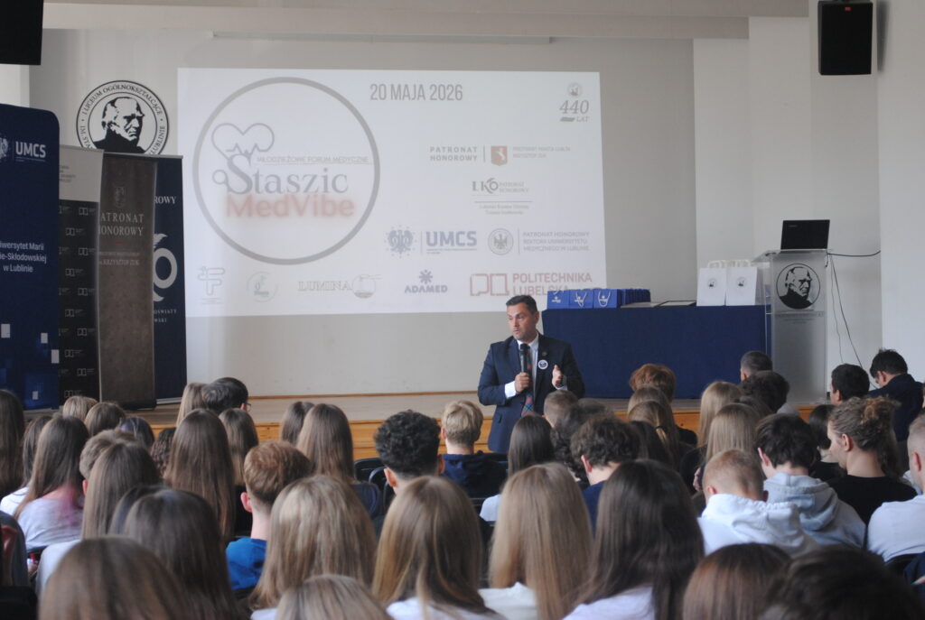 Aula szkolna podczas konferencji medycznej „Staszic MedVibe”. Prelegent przemawia do licznie zgromadzonych uczniów, a na ekranie wyświetlona jest prezentacja wydarzenia.