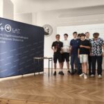 Kilku uczniów stoi obok siebie na tle granatowej ścianki z napisem „440 Staszic”. Pozują do wspólnego zdjęcia po zakończeniu wydarzenia, uśmiechając się do aparatu. Fotografia dokumentuje uczestników turnieju.