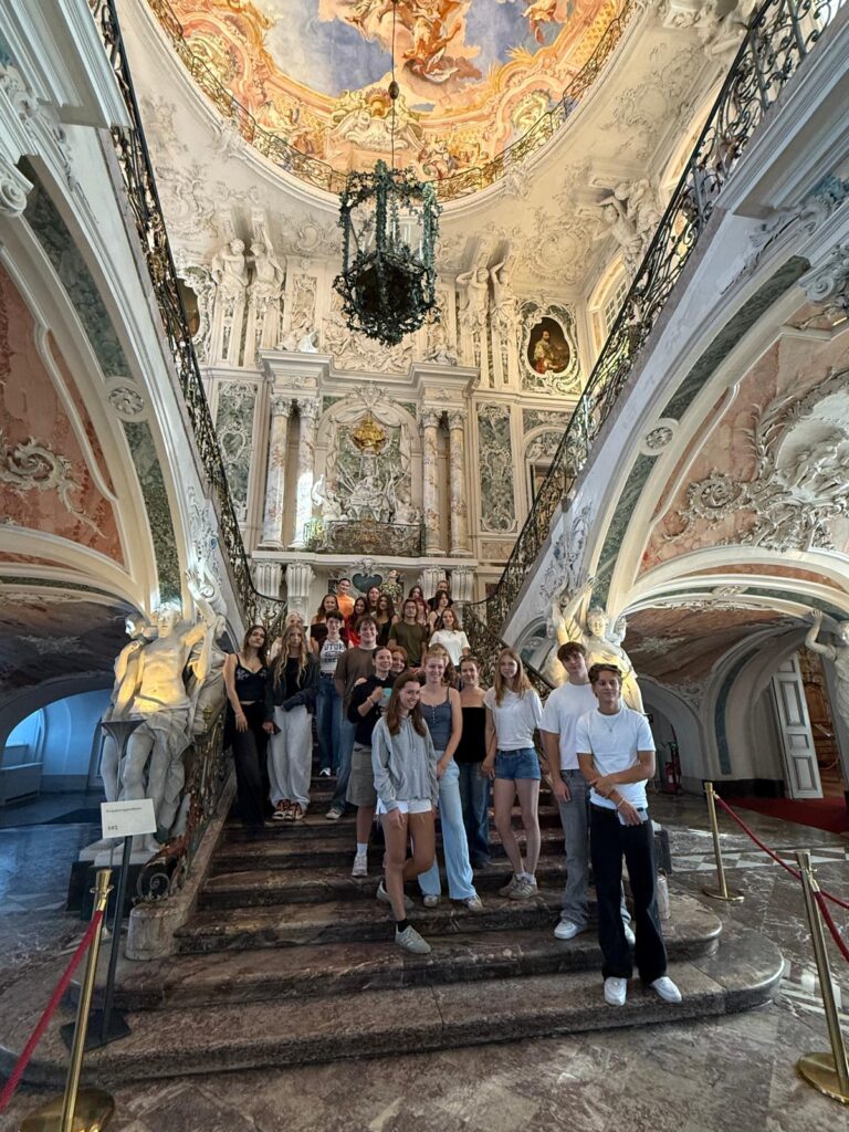 Zbliżenie na setki kłódek zawieszonych na stalowej konstrukcji mostu. Kłódki mają różne kolory, kształty i rozmiary; na części znajdują się imiona, daty i krótkie napisy. Szczególnie widoczne są czerwone kłódki w kształcie serca oraz jasna kłódka-serce z odręcznym napisem.